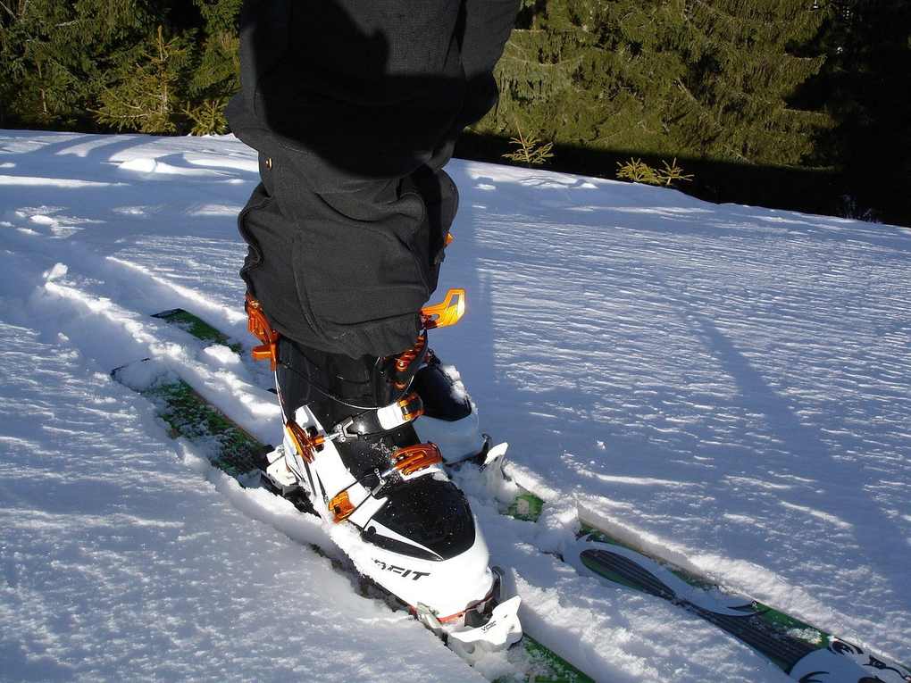 Chaussettes noires et skis sur la neige, forêt en arrière-plan