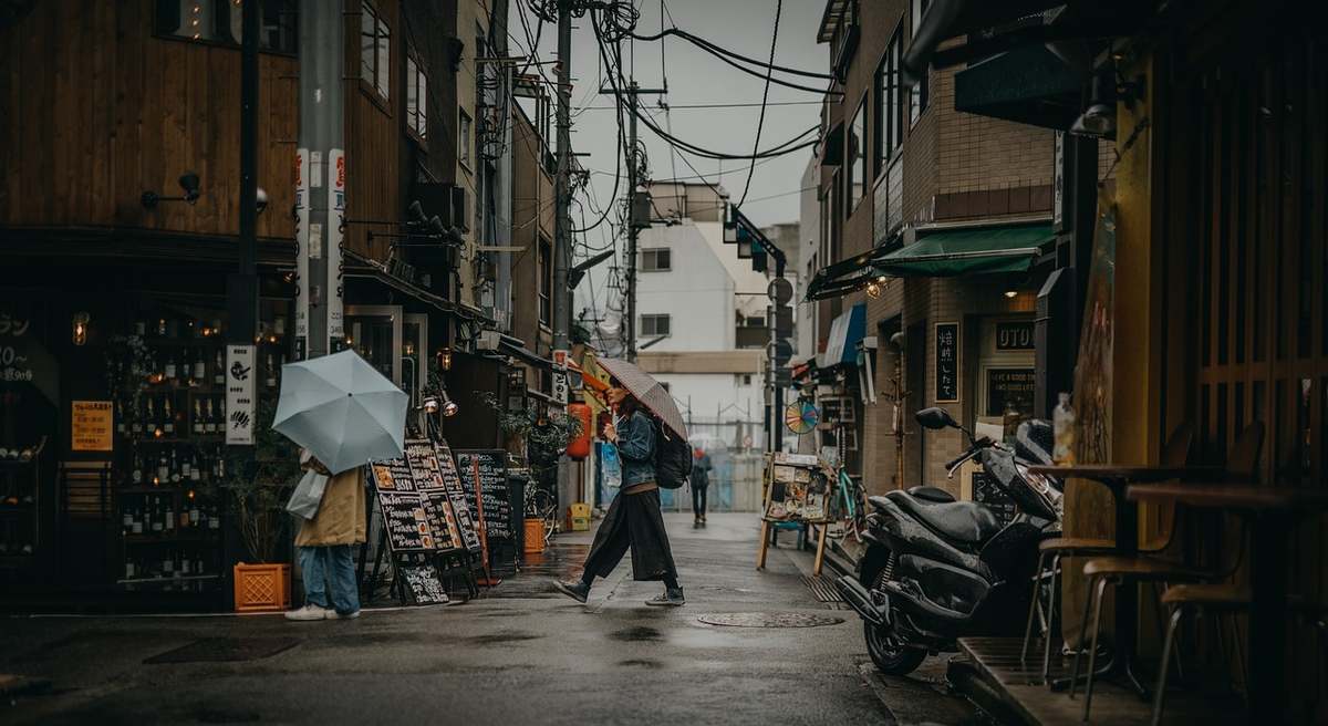 une rue humide sous la pluie avec piétons et véhicules